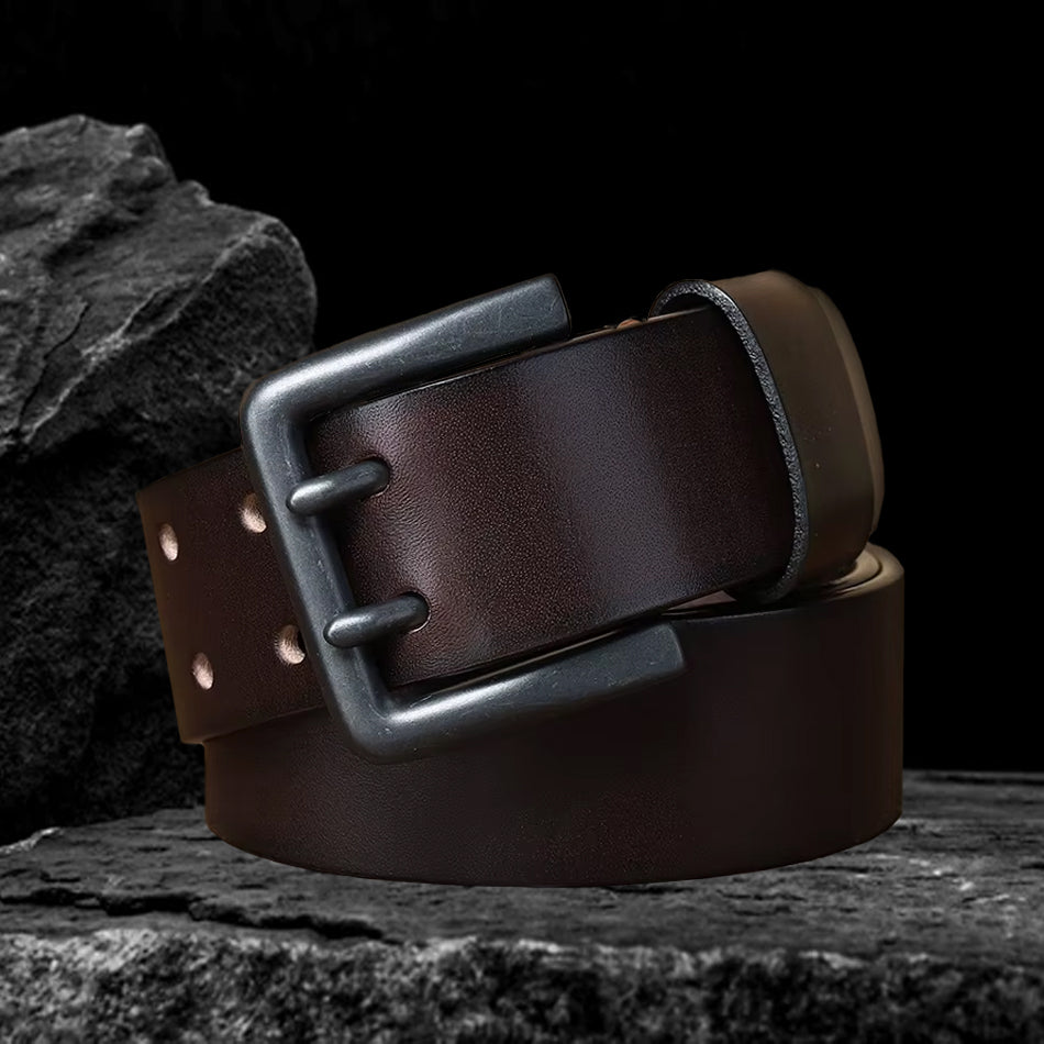 Echtleder-Gürtel aus braunem Rindsleder auf schwarzem Steinfelsen – leicht schräge Perspektive