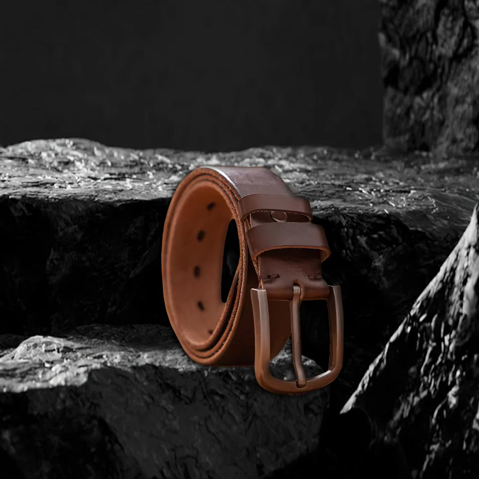 Echtleder-Gürtel aus braunem Rindsleder auf schwarzem Steinfelsen – Gürtel liegt flach, Schnalle sichtbar