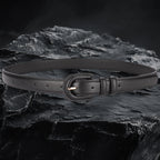 Echtleder-Gurt für Damen aus schwarzem Rindsleder auf schwarzem Steinfelsen – Frontansicht mit Schnalle