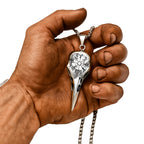 Wikinger Schmuck kaufen, Raben Halskette mit Vegvisir Rune aus Edelstahl – getragen in einer muskulösen Wikingerhand, Symbol für Mut, Schutz und nordische Stärke.