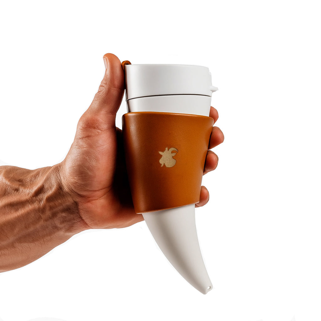 Weisser Thermobecher im Wikinger-Horn-Design mit braunem Lederhalter, fest umschlossen in starker Männerhand