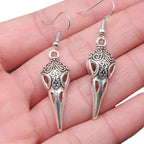 Detailaufnahme von Raben Schädel Ohrringen aus Edelstahl in der Hand präsentiert.