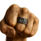 Runen Ring aus Edelstahl mit eingravierter Rune – getragen an einer kräftigen, muskulösen Männerhand im Wikinger-Stil – detailreich gehämmerte Oberfläche, Symbol für Stärke und Schutz – hochwertiger Wikinger Runenschmuck von NORDSKULLS.