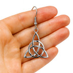 Edelstahl Triquetra Ohrringe in Zarter Wikingerin Damen Hand mit weissem Hintergrund.