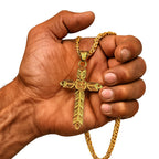 Goldene Wikinger Halskette RAGNARS CROSS aus Edelstahl – Kreuz mit filigraner Gravur, gehalten in einer kräftigen Männerhand