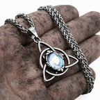 Halskette Damen mit Triquetra Knoten aus Edelstahl und blauem Stein in der Hand gehalten